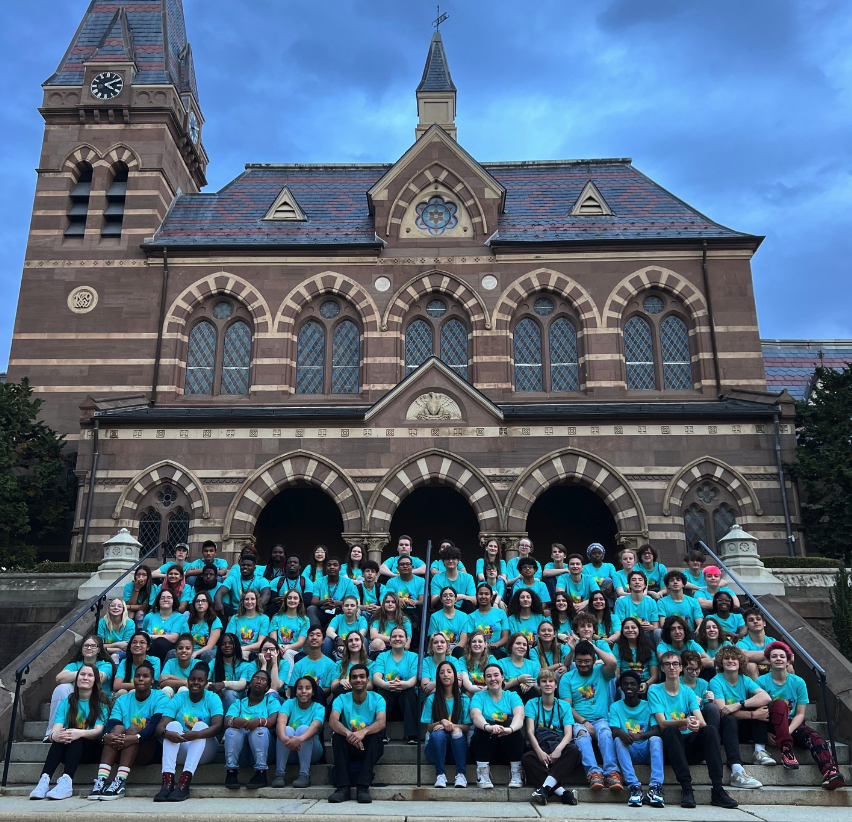JR NAD conference attendees posed at outside building at Gallaudet University. They all wore bright blue t-shirts.